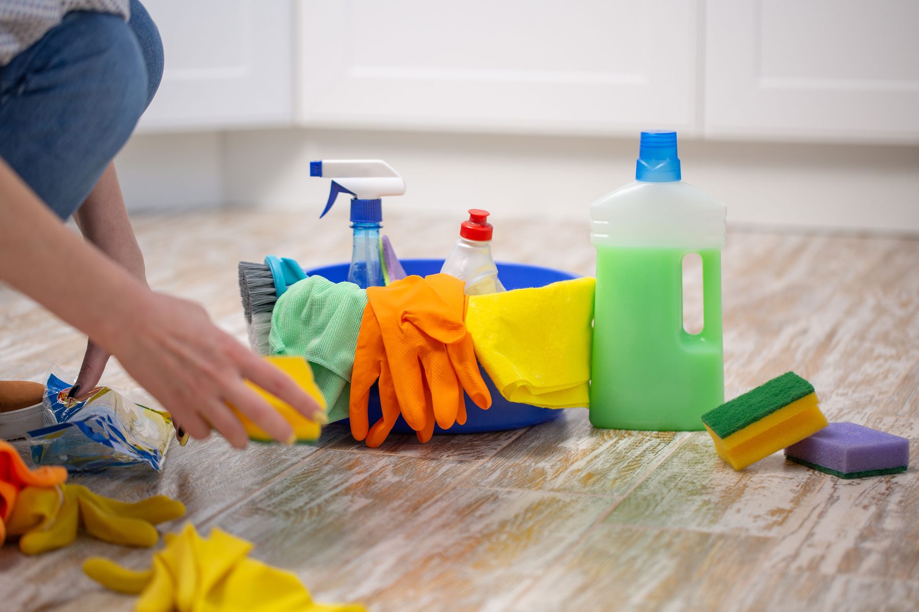Cleaning supplies laid out on a kitchen floor